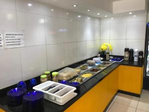 a kitchen with a counter with food on it at Hotel Lucena in Guarabira