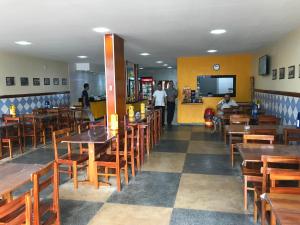 une salle à manger avec des tables et des chaises en bois dans l'établissement Hotel Lucena, à Guarabira