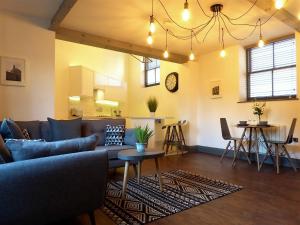 a living room with a couch and a table at Stables at The Coach House Apartments in Leeds