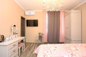 a bedroom with a bed and a desk and a tv at Shabby chic rooms in Zadar