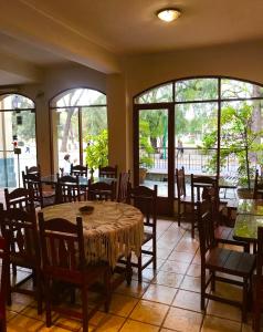 a dining room with a table and chairs and windows at Altoparque Hotel Salta in Salta