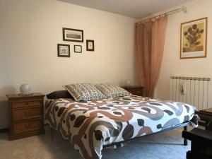ムッジャにあるLa casa di nonna Brunaのベッドルーム1室(ベッド1台付)、木製ドレッサー(ベッドサイドサイドサイドサイド付)