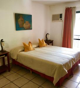 a bedroom with a large bed with yellow pillows at Altoparque Hotel Salta in Salta