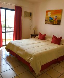 a bedroom with a large bed with red pillows at Altoparque Hotel Salta in Salta +19 photos