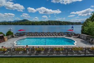 a swimming pool with a lake in the background at High Peaks Resort in Lake Placid