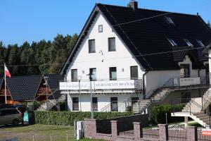 un gran edificio blanco con techo negro en Apartamenty Dom Bałtycki, en Wicie