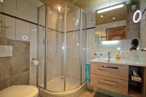 a bathroom with a shower and a toilet and a sink at Gästehaus Amort in Ramsau