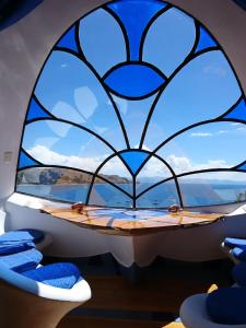 a window with a blue and white window and a blue and white boat at Hostal Las Olas in Copacabana