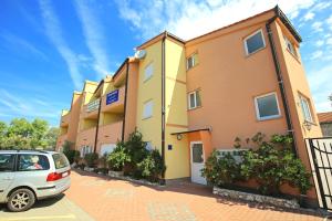 budynek z zaparkowanym przed nim samochodem w obiekcie Apartments SOLARIS - with PRIVATE PARKING w mieście Sveti Filip i Jakov