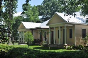 a small yellow house with a metal roof at The Inn at Houmas House Estate in Darrow