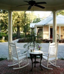 two chairs and a table with a plant on a porch at The Inn at Houmas House Estate in Darrow