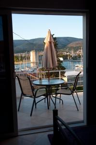 una mesa y sillas con una sombrilla en el balcón en Villa Espero, en Trogir