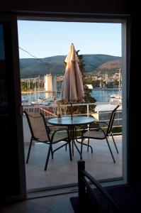 een tafel en stoelen met een parasol op een balkon bij Villa Espero in Trogir