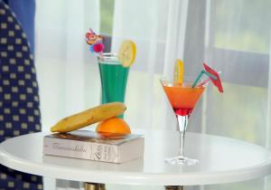 a white table with a drink and a book and a banana at Millenium Palace in Ohrid