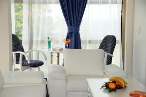 a living room with a white couch and chairs at Millenium Palace in Ohrid