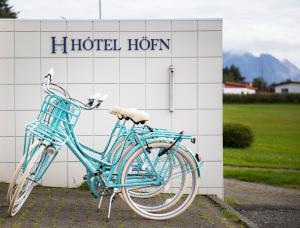 Una bicicleta azul estacionada frente a un hotel horkun en Hotel Höfn en Höfn