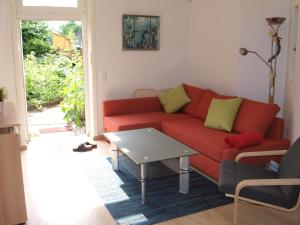 a living room with a red couch and a table at Appartement-im-Lebenstor-Angeln in Sterup
