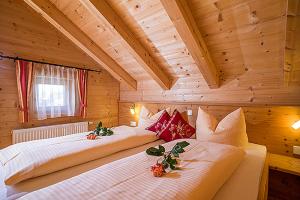 A bed or beds in a room at Achenseer Hüttendörfl