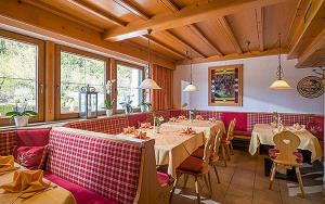 un ristorante con tavoli e sedie in una stanza di Achenseer Hüttendörfl a Maurach
