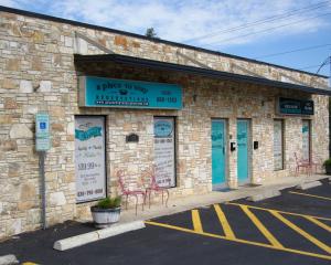 a brick building with tables and chairs on a street at A Place to Stay Rooms in Bandera