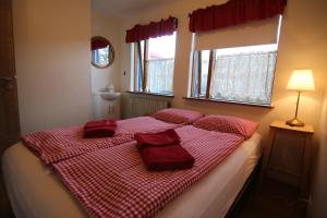 ein Bett mit roten Kissen darauf im Schlafzimmer in der Unterkunft CJA Guesthouse in Laugar