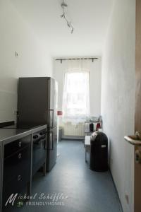 een keuken met een roestvrijstalen koelkast en een raam bij Smart and Happy Living Fürth in Fürth