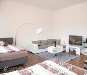a white living room with a couch and a tv at Smart and Happy Living Fürth in Fürth