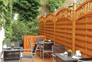 a wooden fence with tables and chairs on a patio at Pension am Heusteig in Stuttgart