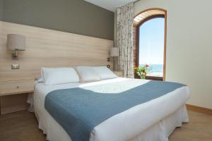 a bedroom with a large bed with a window at Hotel Campanario Del Mar in La Serena