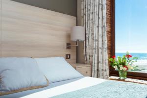 a bedroom with a bed and a window at Hotel Campanario Del Mar in La Serena