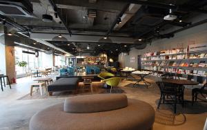 a room with tables and chairs and a book store at Calendar Hotel in Otsu