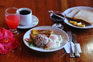 a table with two plates of breakfast food and a cup of coffee at Hotel El Atardecer in Monteverde Costa Rica