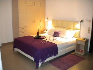 - une chambre avec un grand lit et une bouteille de vin dans l'établissement Katerina Studios & Apartments, à Ierápetra