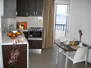 eine Küche mit einem Tisch und einem Herd Top-Backofen in der Unterkunft Katerina Studios & Apartments in Ierápetra