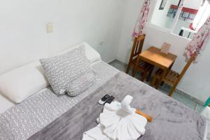- une chambre avec un lit et des serviettes dans l'établissement Posada Paso Del Sol, à Isla Mujeres