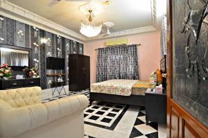 een slaapkamer met een bed en een bank in een kamer bij Hotel Blue Sky Executive in Karachi