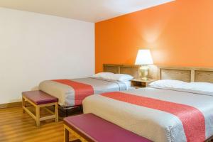 two beds in a room with orange walls at Motel 6-Madras, OR in Madras