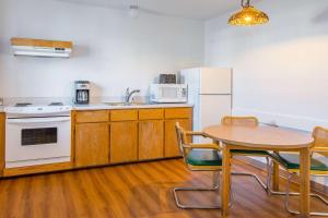 a kitchen with a table and a white refrigerator at Motel 6-Madras, OR in Madras