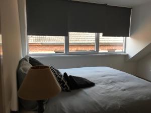 a bedroom with a bed and a large window at Caramel in Turnhout