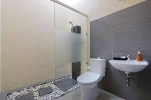 ein Badezimmer mit Dusche, Toilette und Waschbecken in der Unterkunft ThanTha Ubud Villa in Ubud