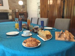 a table with a blue table cloth with food on it at Chambres d'hôtes Penker in Minihy-Tréguier