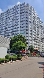 un grand immeuble d'appartements avec un parking en face de celui-ci dans l'établissement Popular Condo by Jintana, à Pak Kret