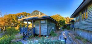 a small house with a gabled roof next to a building at Fraser Island Retreat in Fraser Island