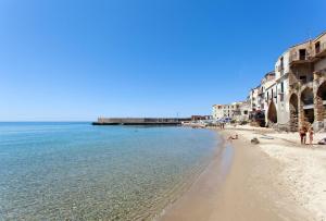 チェファルにあるNido al Mare - by Vacation Serviceの建物と水辺のビーチの景色を望めます。