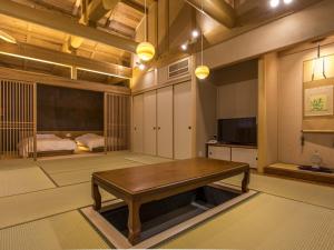 Yunotani Senkei في Totsukawa: غرفة معيشة مع طاولة خشبية وغرفة نوم