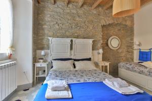 Un dormitorio con una cama azul y una pared de piedra en Mare amore @ Riomaggiore, en Riomaggiore