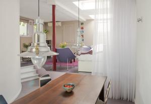 a dining room with a wooden table and a room with a bed at Bed & Office 050 in Groningen