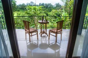 a balcony with a table and two chairs and a view at Pondok Bali in Ubud