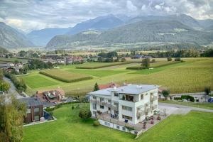 una vista aérea de una casa con montañas en el fondo en Garni Schorneck, en Brunico
