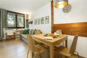 sala de estar con mesa de madera y sillas en Apartment Chamois Blanc 1 en Chamonix-Mont-Blanc